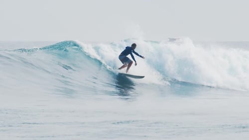 Surfer Rides the Wave in the Maldives