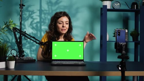 Influencer in Home Studio Reviewing Chroma Key Laptop