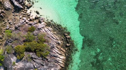beach rocky cliff island turquoise blue sea. Majestic aerial top view flight vertical bird's eye vie