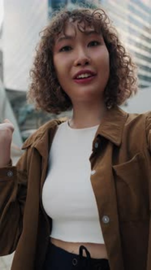 Smiling Woman Waving in City Urban Setting