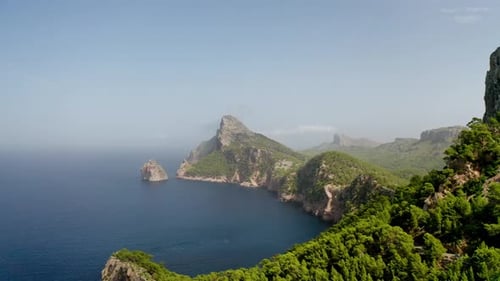 Drone shot of a Caribbean green island landscape with hills and mountains surrounded by sea water