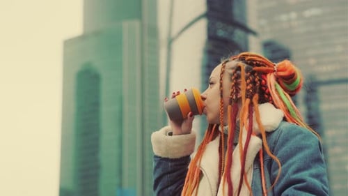 Woman Drinks Coffee in City Environment