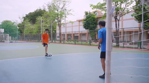 Asian two sportsman practicing football playing in the outdoors stadium.