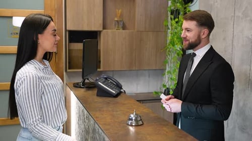 Hotel Receptionist Giving Key Card to Female Guest for Check in