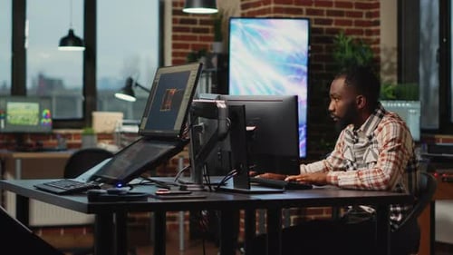 Afroamerikanischer Webentwickler arbeitet im künstlerischen Büro an der Erstellung von CGI-Inhalten