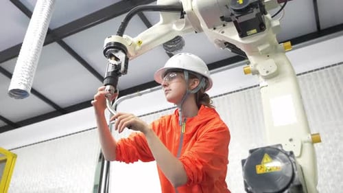 Un ingénieur programme un bras robotique pour des tâches de précision dans une installation moderne
