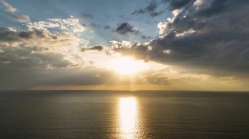 Aerial View The Mediterranean Sea Glows Under a Golden Sunset with Dramatic Cloud Formations