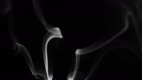 Wispy white smoke rising in the dark background