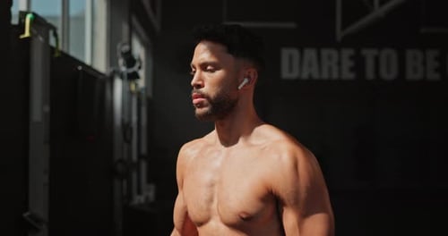 Music, dumbbell and man workout for muscle, wellness and body health in gym