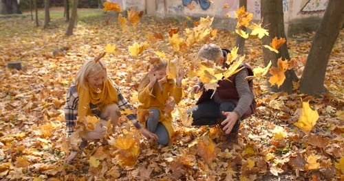 Small Girl with Grandparents on a Walk in Autumn Forest