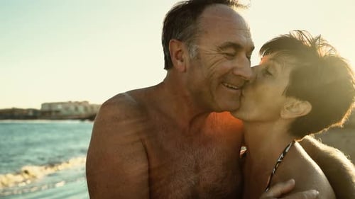 Happy senior couple having a romantic moment on the beach at sunset during summer vacations