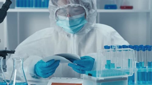 Researcher Analyzing Data in Protective Suit