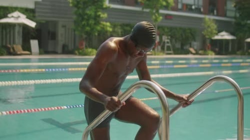 Nadador que entra a la piscina exterior