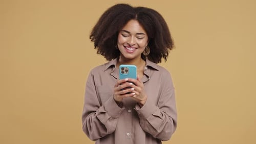 Smiling Woman Using Smartphone on Neutral Background