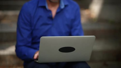 Des mains concentrées qui tapent assidûment sur un ordinateur portable dans un environnement moderne et dynamique