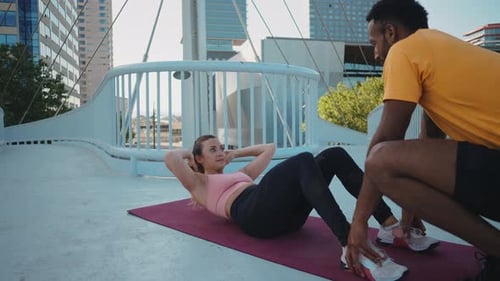 Woman Doing Sit-ups with Partner in City