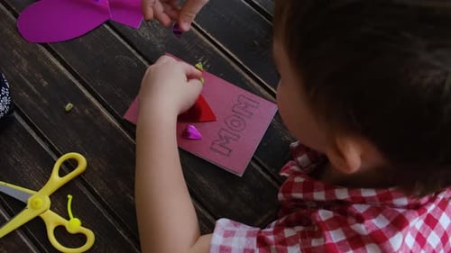 Kleiner Junge bastelt DIY-Grußkarte zum Muttertag