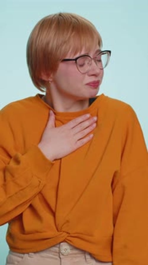 Young Woman with Coughing Symptoms Holds Chest Indoors