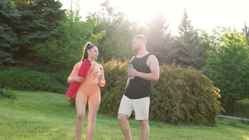 Athletic Couple Walking Together in a Green Park
