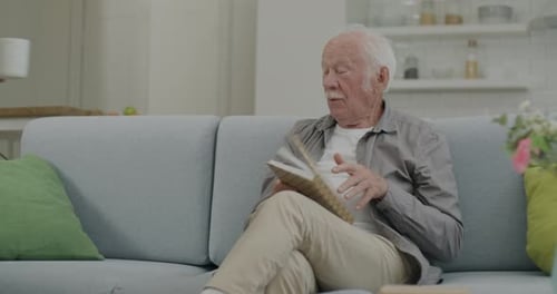Senior Couple Relaxing with Coffee and Book at Home