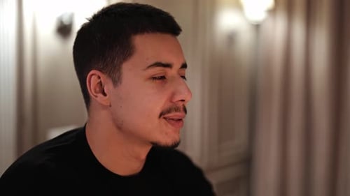 Young Man Smiling and Talking Indoors