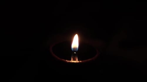 Solitary Candle Flame Flickering in the Dark