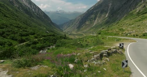 Aerial Flying Past Roadside Building Beside Winding Valley Road Out Towards Valley Of The Grimsel Pa