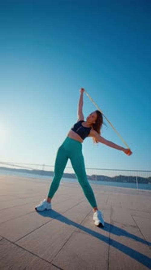 Woman Exercises with Resistance Band on a Sunny Day