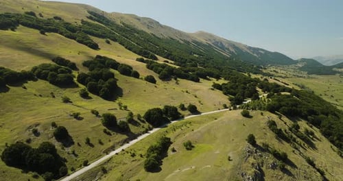 Aerial view of road winding through mountains, Italy.