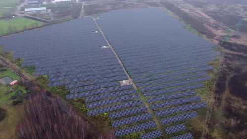 Massive solar panel field seen from above in rural Latvia during overcast weather