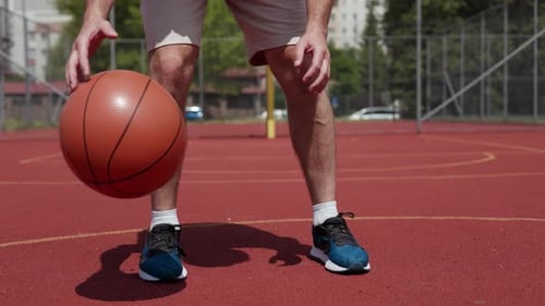 Energetic Male Dunking Basketball While Standing in Middle of Orange Court