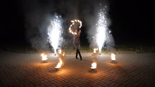 Fire Dancer Performs with Fireworks at Night