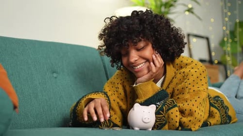 Saving Money Investment for Future African American Girl Putting Money Coin in Pink Piggy Bank