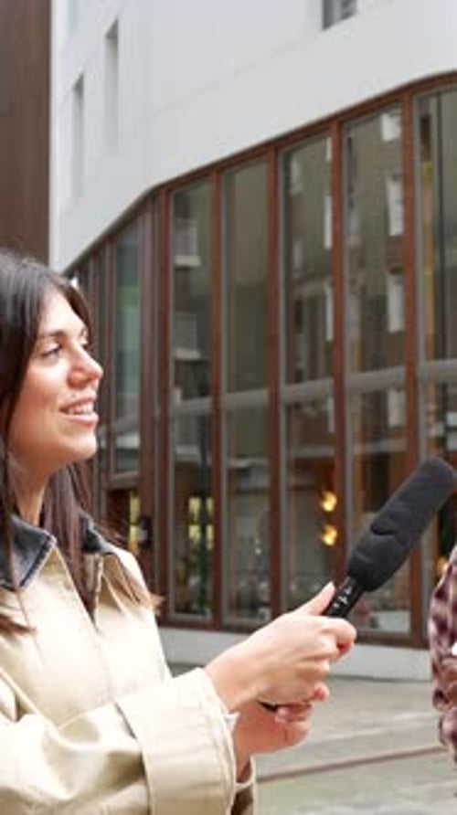 Periodista realizando una entrevista callejera con un joven