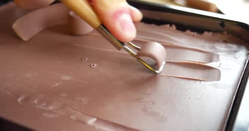 Façonner de l'argile brune lisse avec un outil de poterie en forme de boucle métallique pour la sculpture