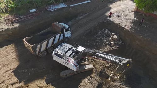 Excavator Filling Dump Truck On Construction Site
