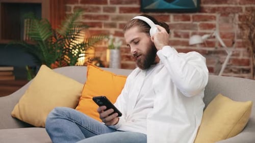 Bearded Man Singing with Headphones and Mobile Phone
