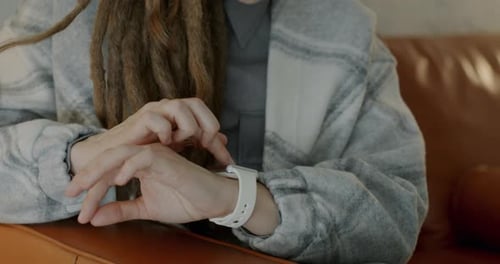 Person Using Smart Watch While Sitting on Couch