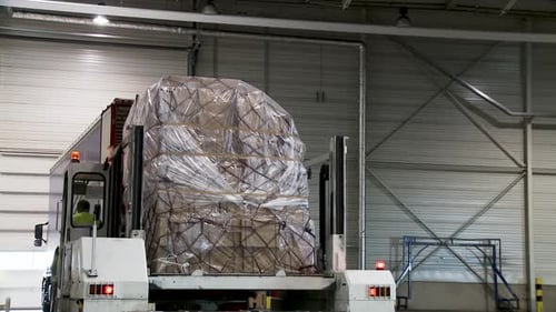 Efficient Warehouse Operations: Loading Heavy Cargo Pallets onto Transport Trucks