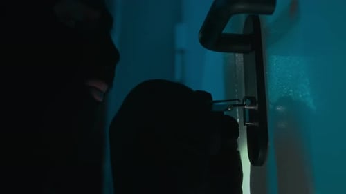 Close-up of Criminal in Balaclava Picking Lock Trying to Break into House