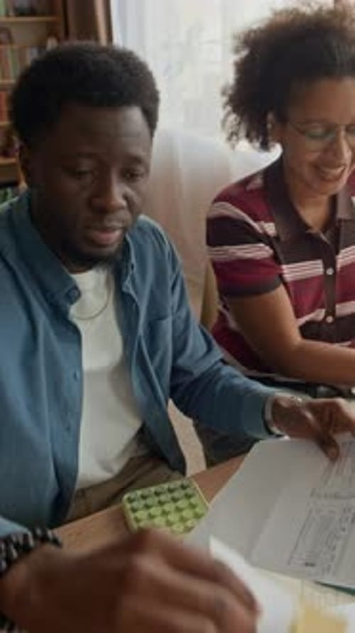Man and Woman Reviewing Financial Documents at Home