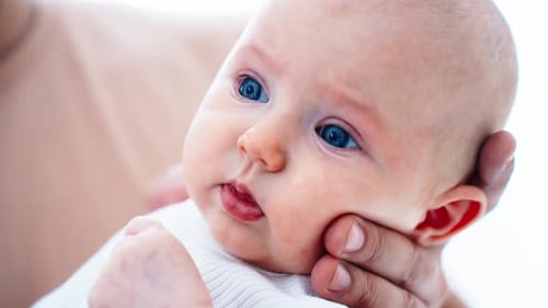 Sweet Infant Held Gently Indoors in Close Up