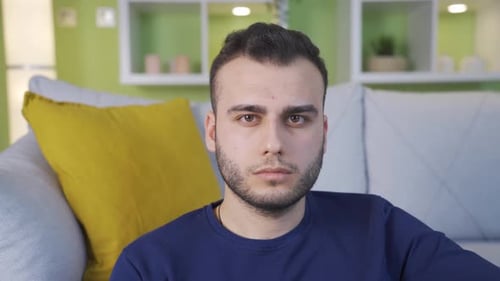 Portrait of a thoughtful, unhappy and depressed man at home.