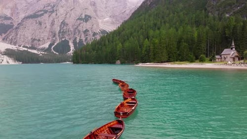 Botes de remos de madera del Lago di Braies y parque natural circundante, Dolomitas, primer plano aéreo