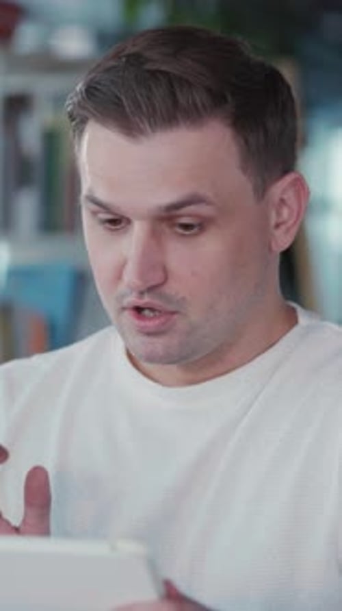 Man Talking on Tablet Indoors in Portrait Video