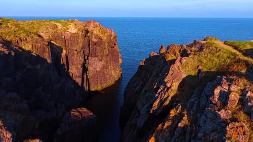 Footage among the sunlit rocks at the coast of the sea or ocean.