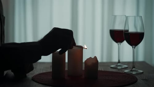 Romantic Evening By Candlelight Hands of a Man Lighting Candles with Matches Close Up Burning