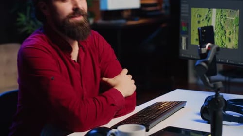 Man Recording Video on Smartphone in Workspace