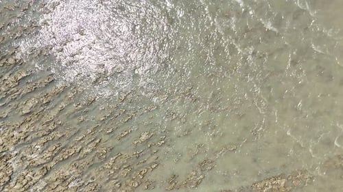 Drone View of Coastal Erosion with Mud Flats and Murky Waters
