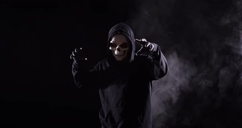 Hooded Figure in Skull Mask with Menacing Gesture
